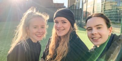 Three University of Leeds students at a sports pitch